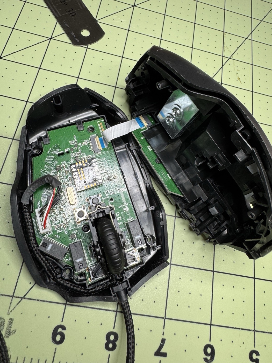 Mouse split open, halves connected by the ribbon cable